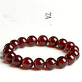 Natural orange red garnet crystal ball bracelet with a traditional metal Ruyi-style clasp.