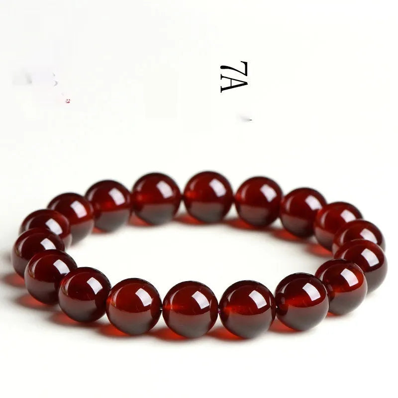 Natural orange red garnet crystal ball bracelet with a traditional metal Ruyi-style clasp.