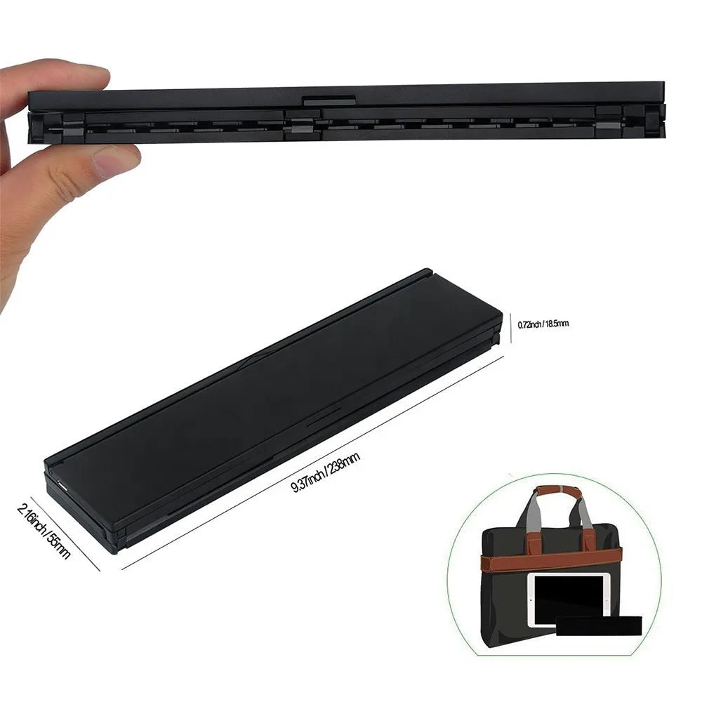 Black folding Bluetooth keyboard with aluminium bottom next to tablet