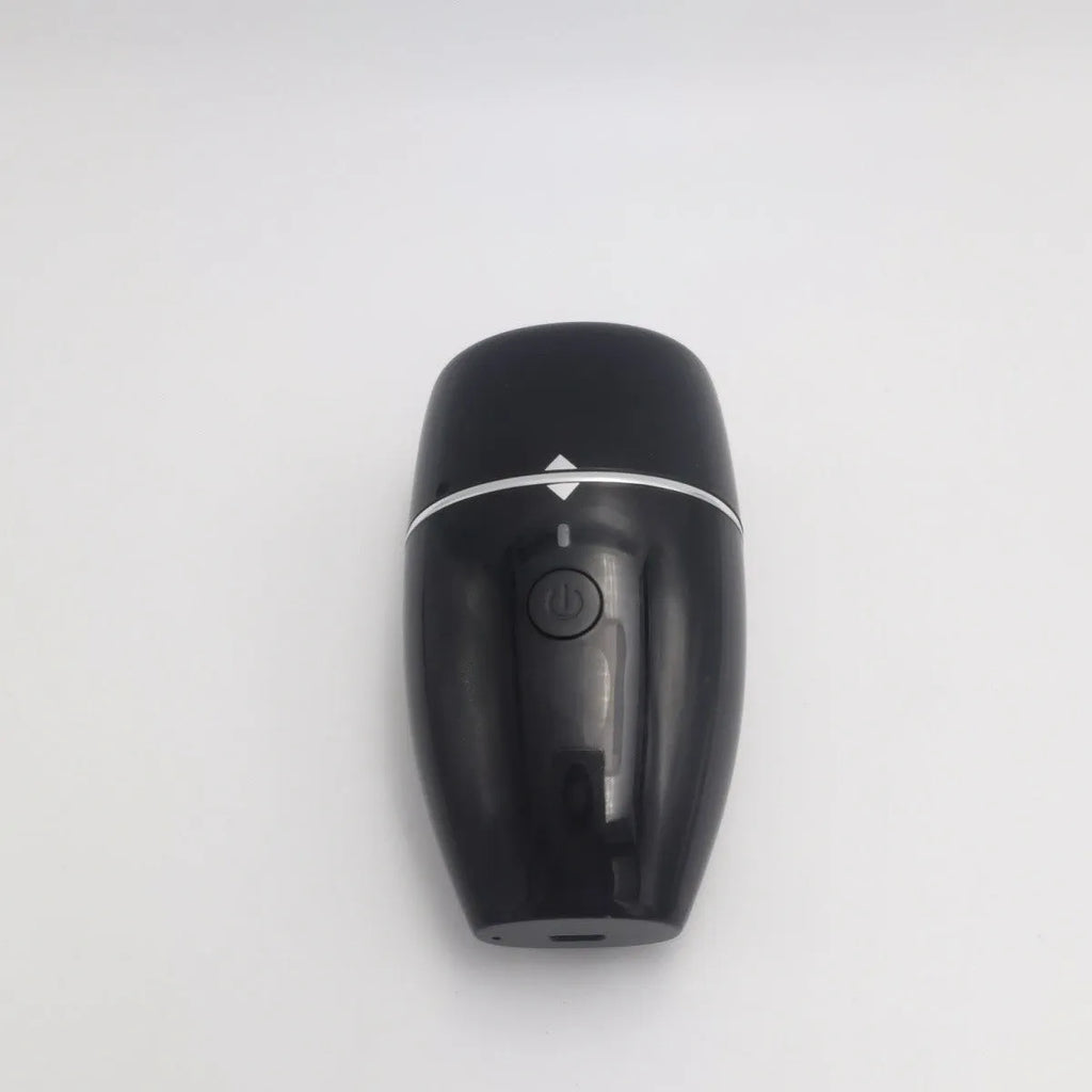 Black and white electric lip plumper device with silicone tip and USB cable on a plain background.
