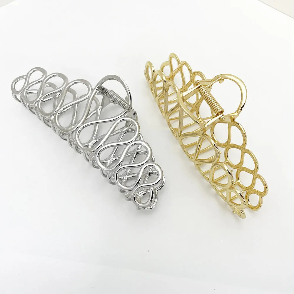Large gold and silver alloy hair clip with a tassel detail on a white background.