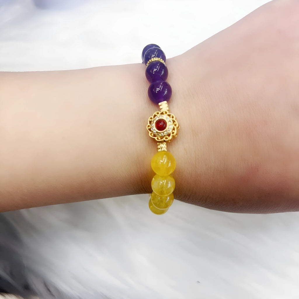 Handmade yellow and purple crystal bracelet for women on a wrist.