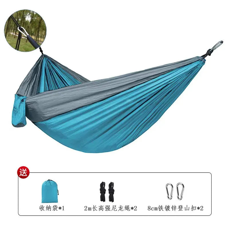 Blue and grey parachute nylon outdoor hammock hung between trees, showing its spacious 270cm length.