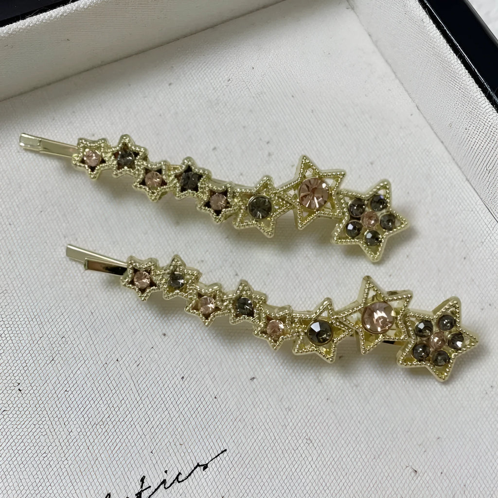 Golden hair clip barrette with a rhinestone five-pointed star, shown on a side angle.