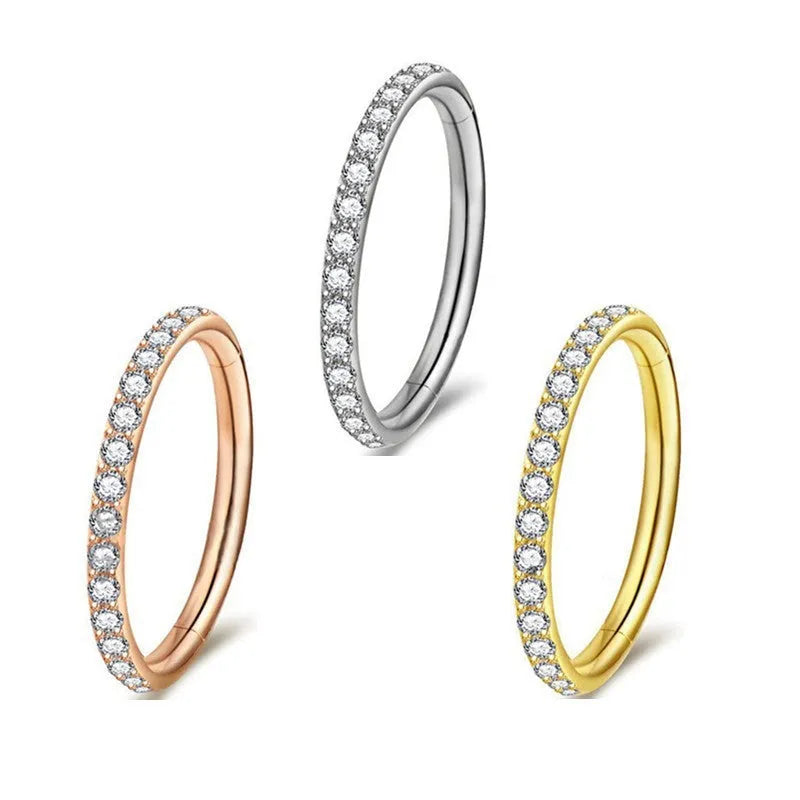 Close-up of a seamless round stainless steel nose ring with a diamond finish, showing colour options including gold, rose gold, and black.