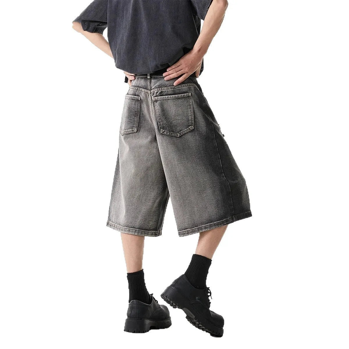 Grey high street washed cotton denim shorts with a loose, cropped fit on a hanger.