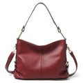 Genuine leather vertical square crossbody bag in black, showing front sandwich pocket and sewing line details.