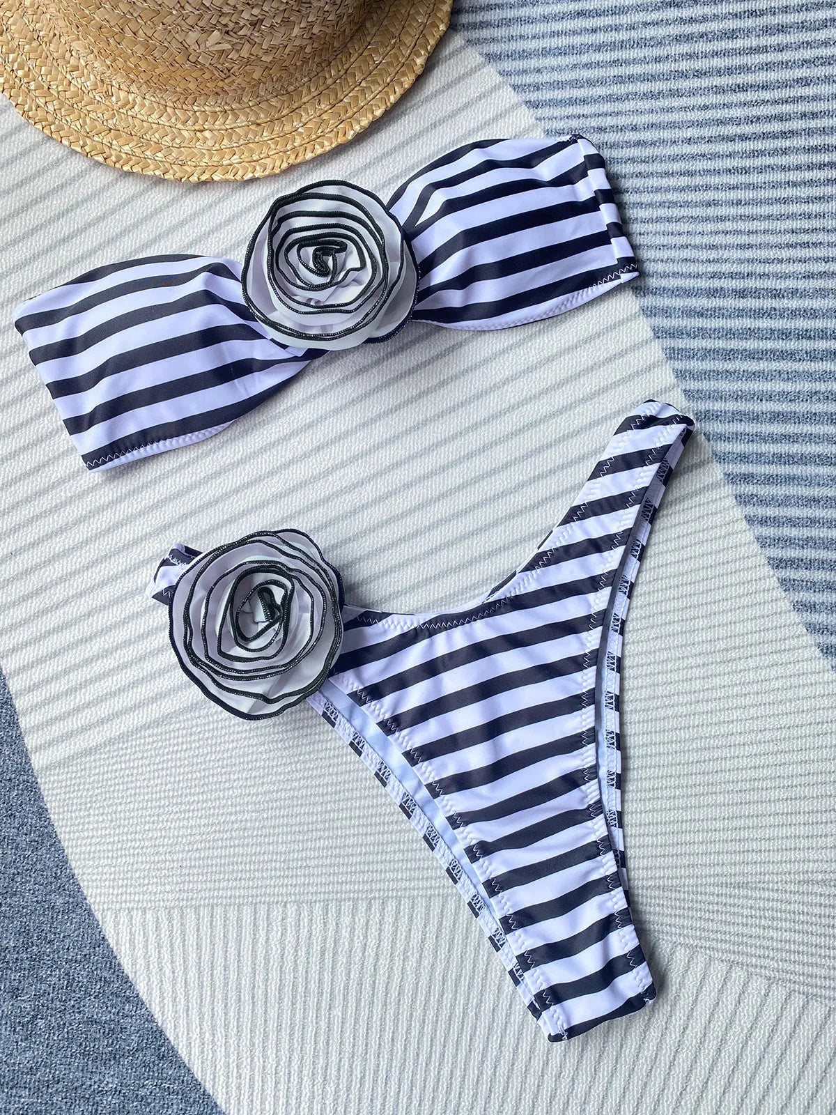 Striped split design bikini swimsuit with cross-back top and three-dimensional flower detail.