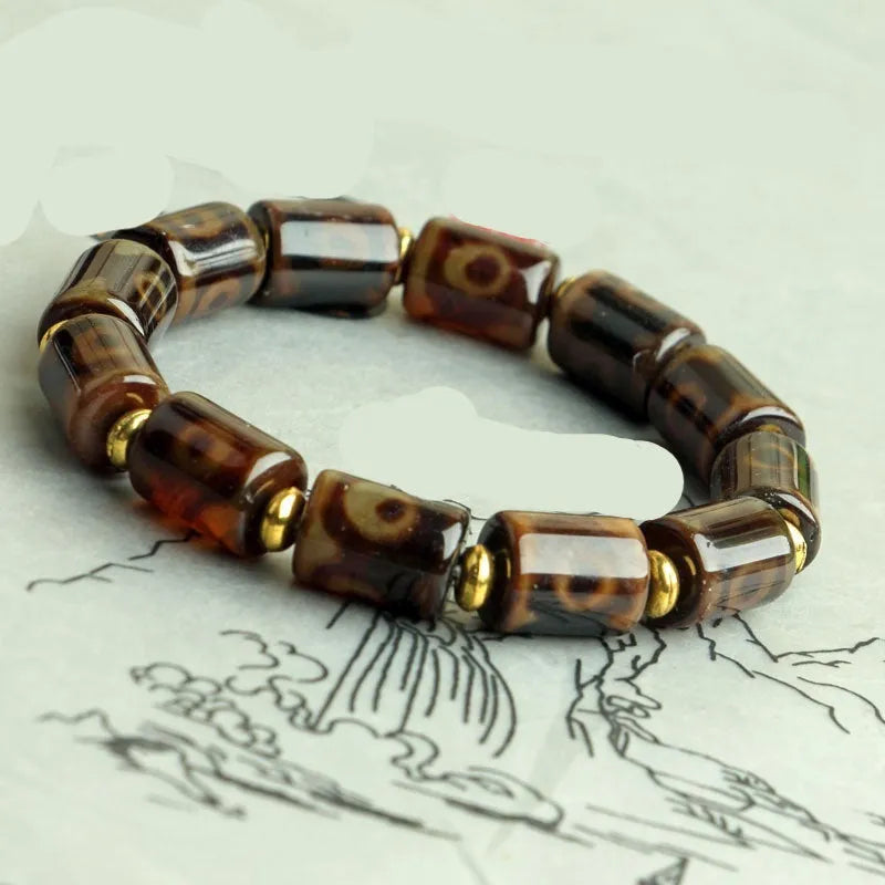Distressed agate Tibet bead bracelet with three-eye motifs and multiple traditional bead styles on wrist