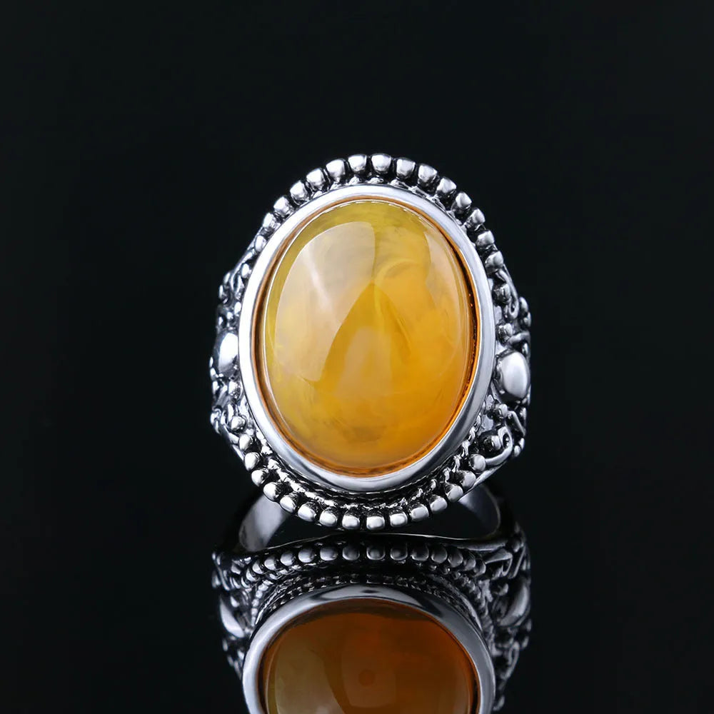 Geometric fluorescent beeswax alloy ring in antique silver amber colour on a grey background.