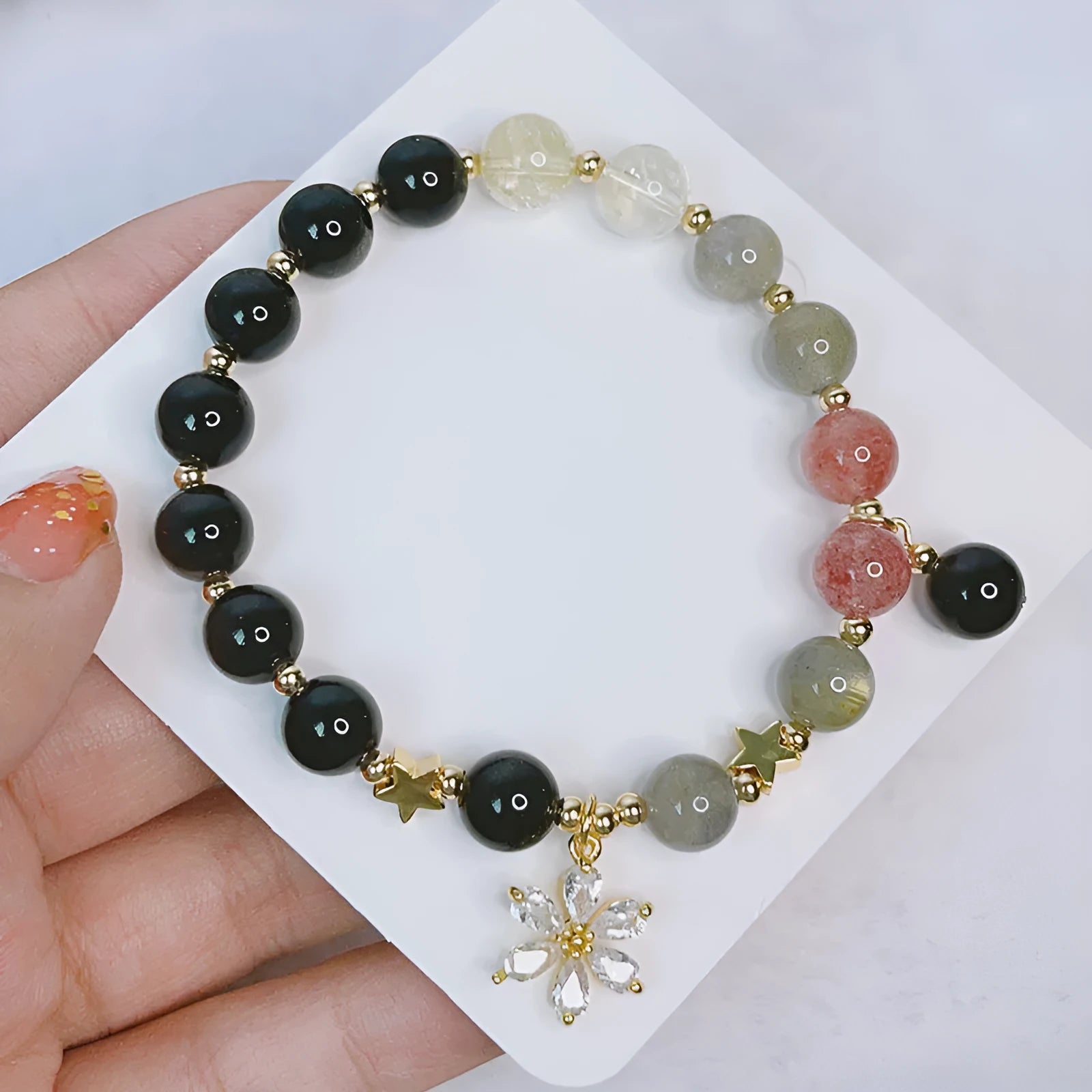 Silver stone bracelet with electroplated finish showing floral, love heart, and star charm designs
