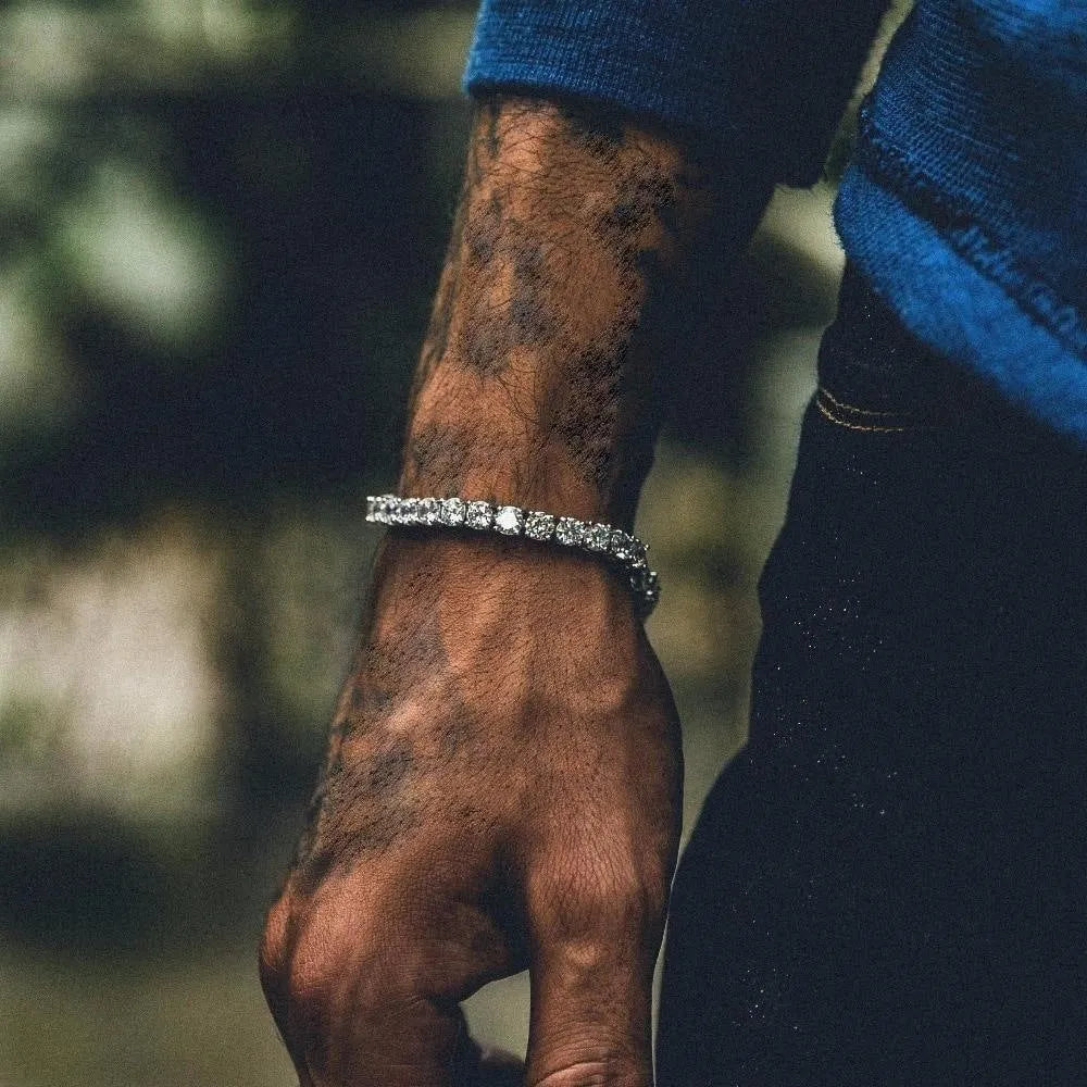 Men's silver geometric chain bracelet with a single row of clear rhinestones on a black background.