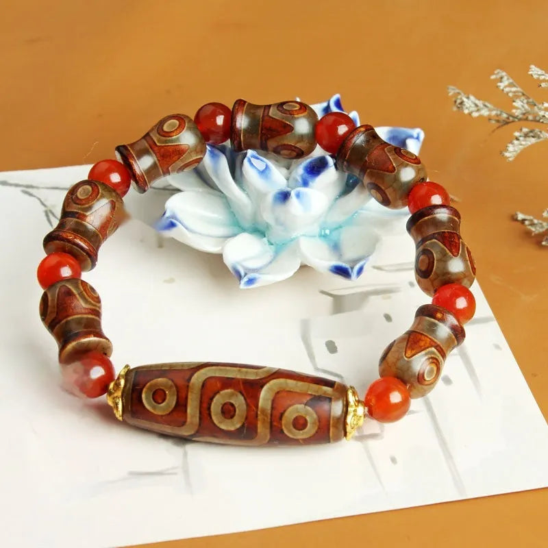 Distressed agate Tibet bead bracelet with three-eye motifs and multiple traditional bead styles on wrist