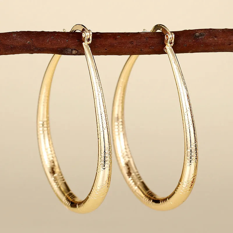 Geometric copper ear clip earrings with ring design detail and electroplated finish