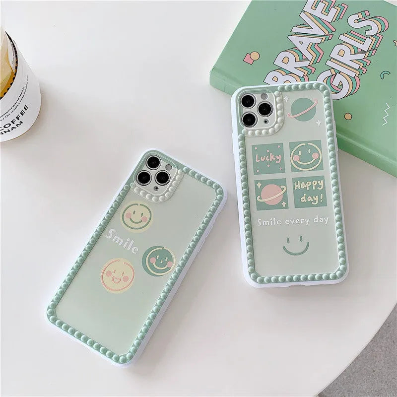 Green TPU iPhone case with geometric smiley face design and polka dot frame on a phone.