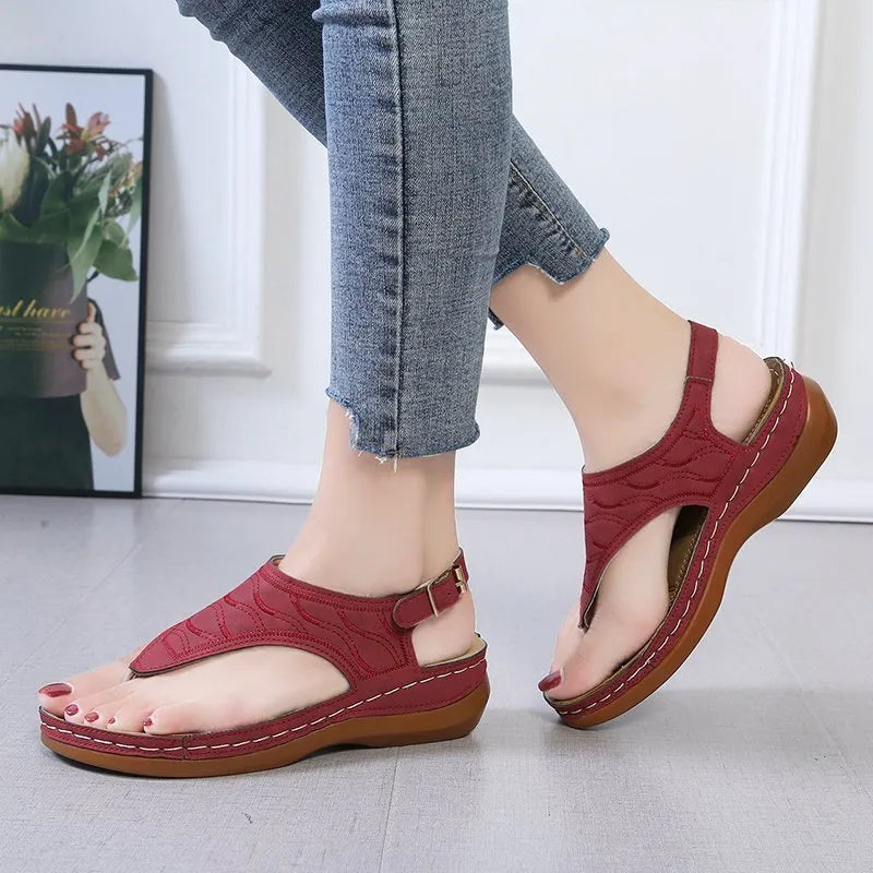 Women's wedge heel flip flop sandals with an adjustable back buckle strap in black.