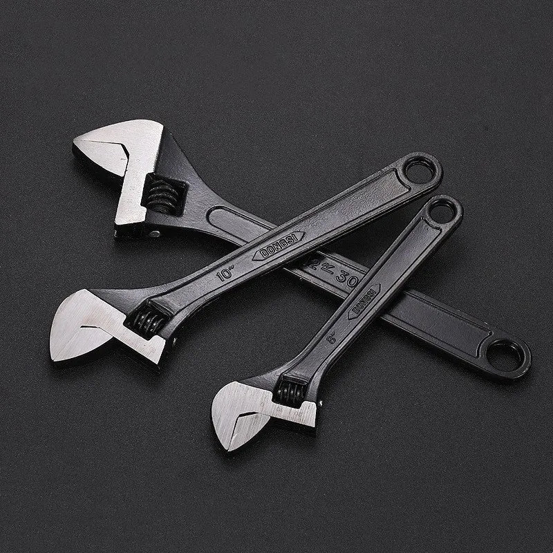 Stainless steel adjustable open-end wrench on a workbench