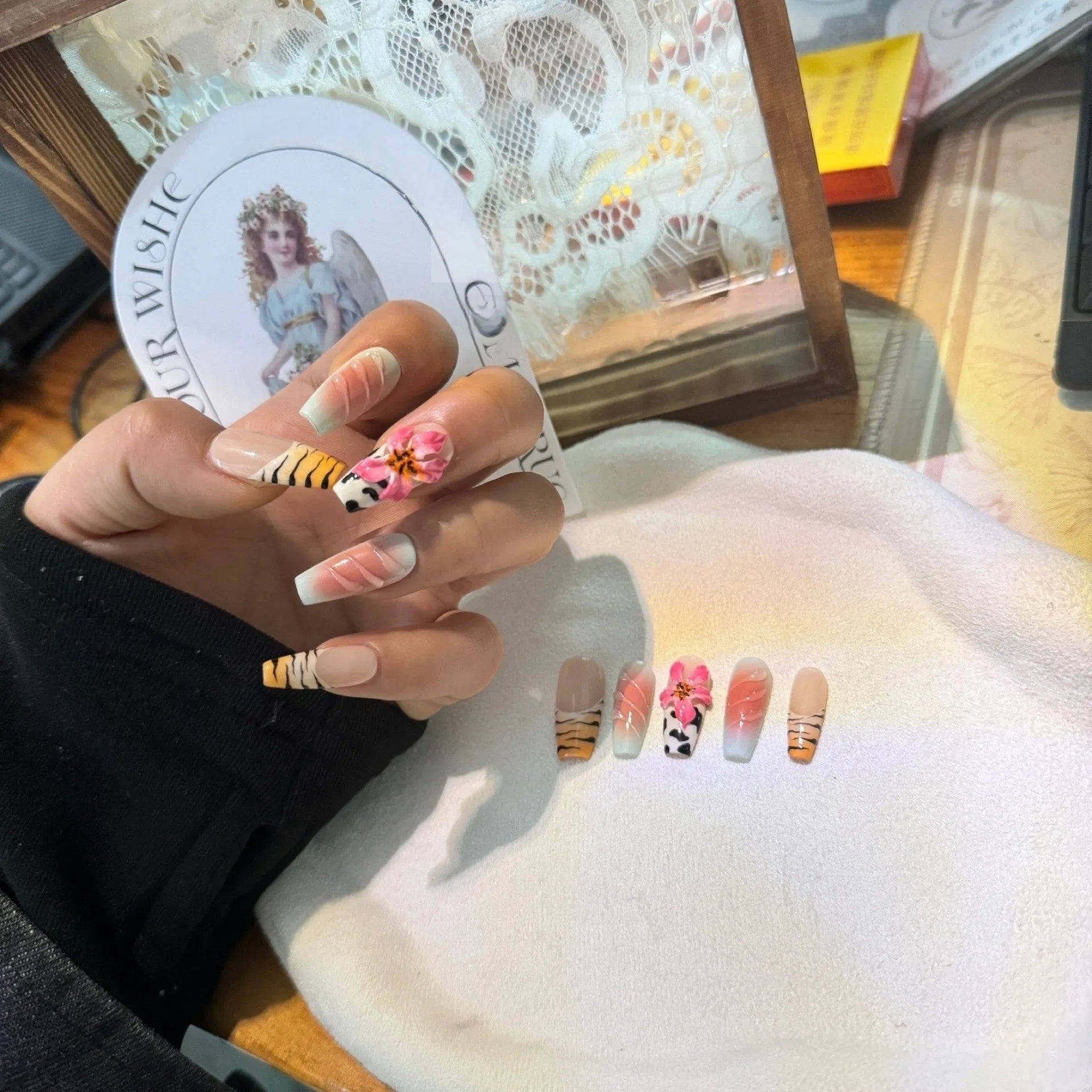 Zebra pattern and Lily hand carving design on a set of long, decorative false nails.