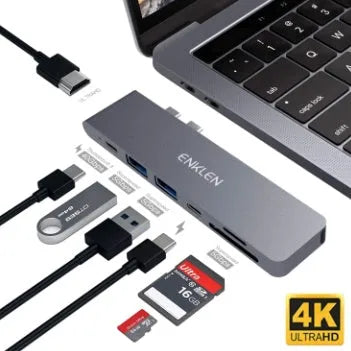 Silver 7-in-1 USB-C hub adapter with SD card reader, HDMI, and USB ports on a wooden desk.