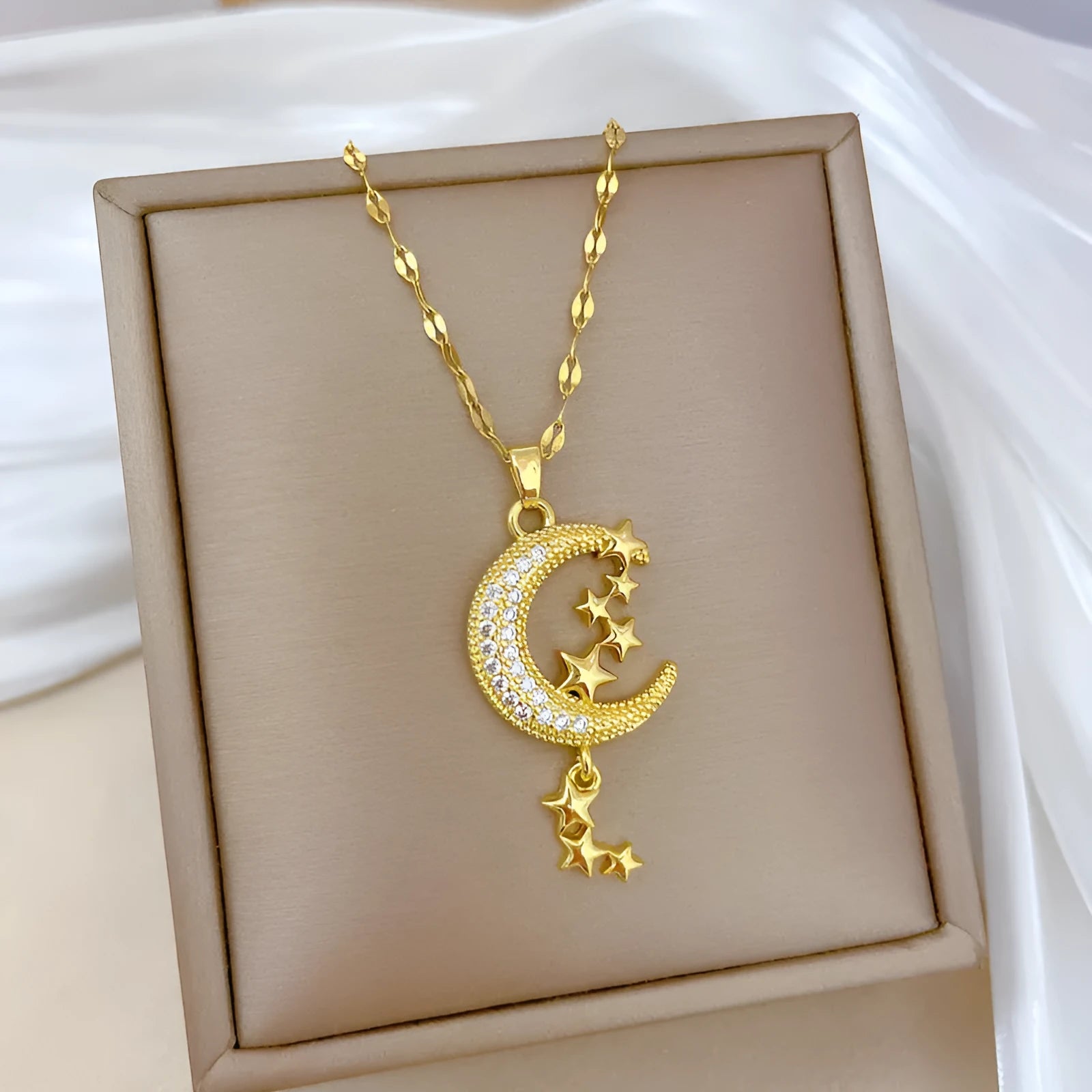 Geometric moon pendant necklace with tassel detailing and diamond accents on copper