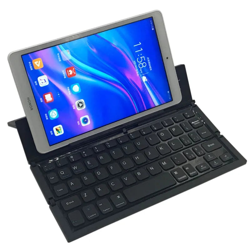 Black folding Bluetooth keyboard with aluminium bottom next to tablet
