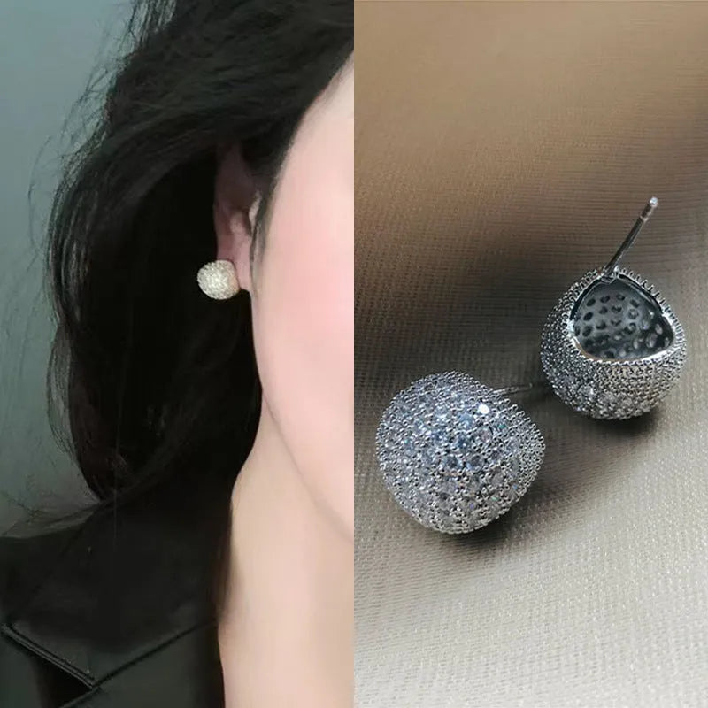 Geometric drop-shaped diamond ear clip earrings in gold and white colours with spherical elements