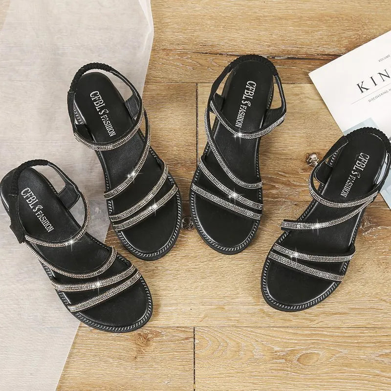 Women's silver flat sandals with rhinestone decoration and elastic band, showing the round toe and rubber sole.