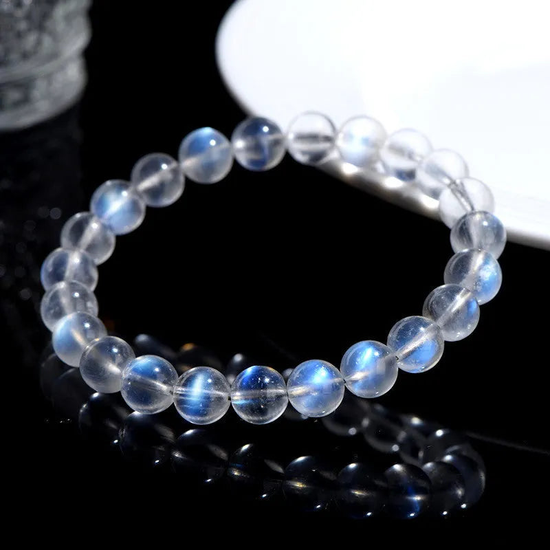 Natural blue moonlight cream body crystal bracelet on a wrist, showing polished beads.