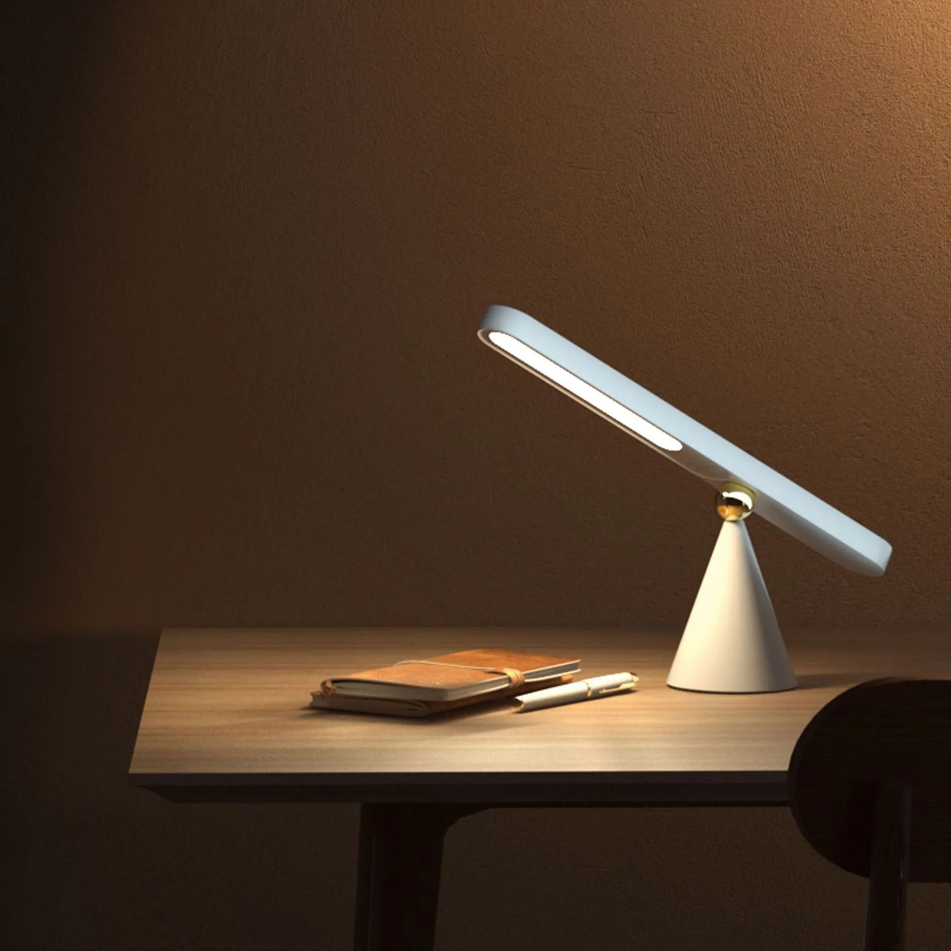Geometric design table lamp with magnetic base on desk next to USB cable