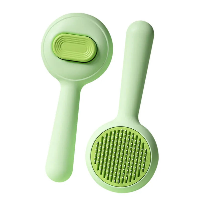 Green cat grooming brush with stainless steel teeth and non-slip handle for pet hair removal