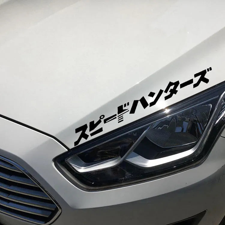Black and white 35x35cm square reflective Japanese car sticker on a vehicle window.