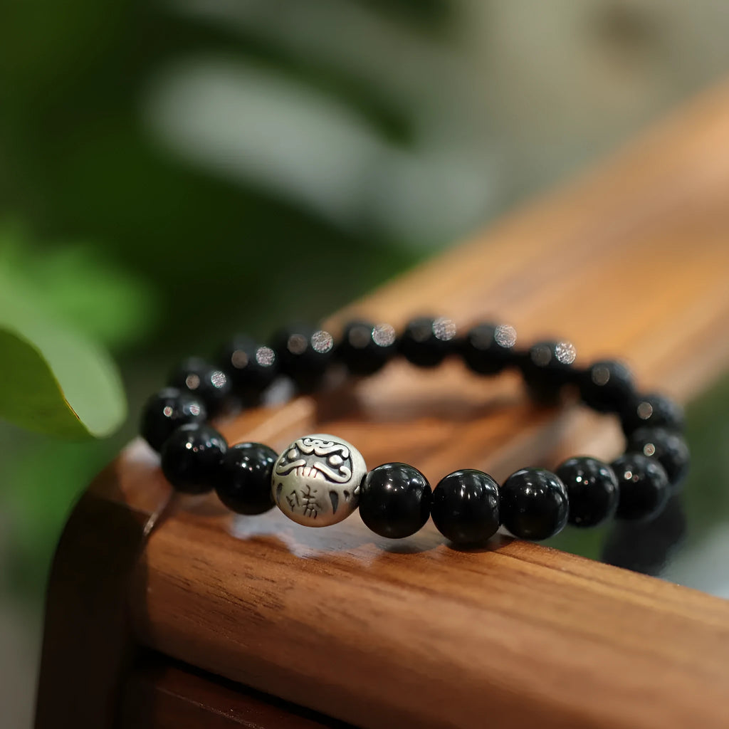 Close-up of a women's bracelet with a 10mm black agate stone and Chinese-style sterling silver and alloy design.