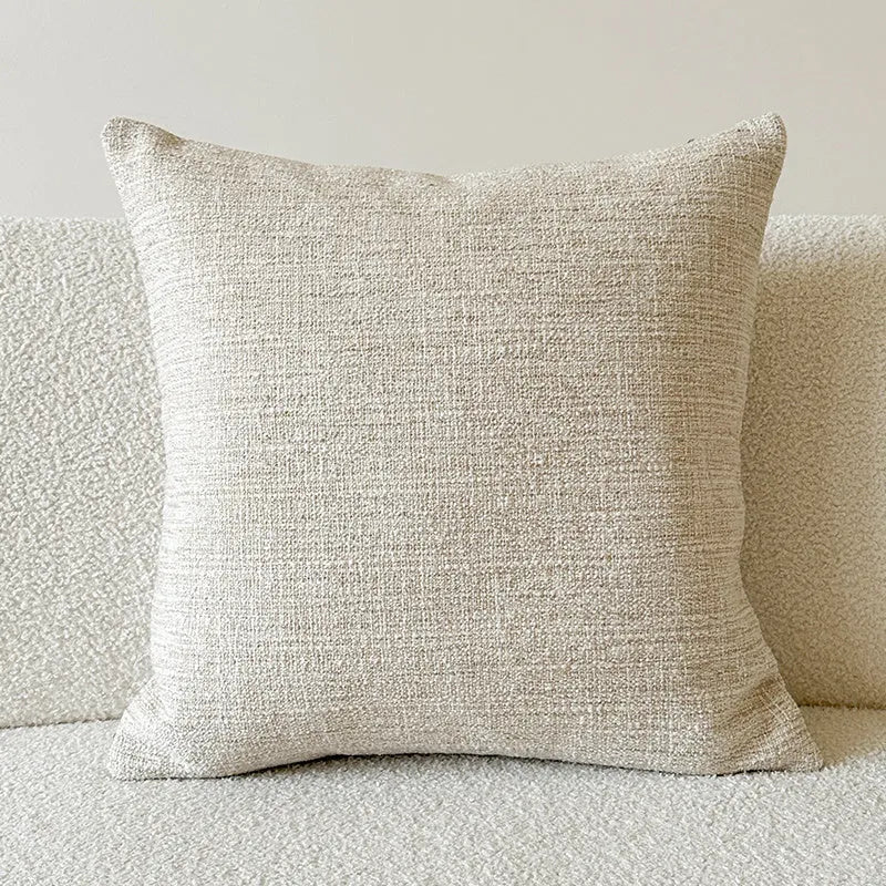 Amber jacquard paisley pillow cover on a sofa, showing textured fabric and botanical pattern.