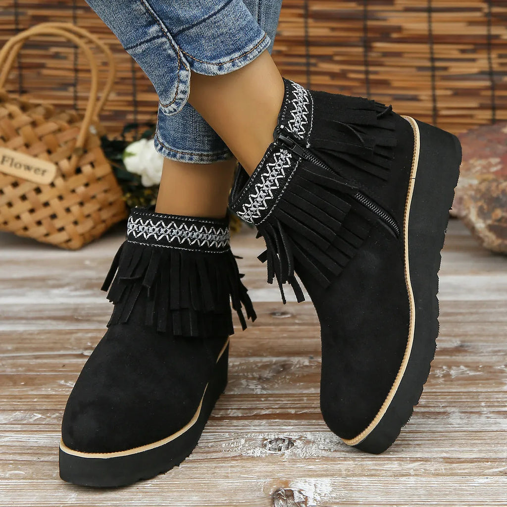 Women's black suede wedge ankle boots with a side zip and tassel detail on a thick rubber sole.