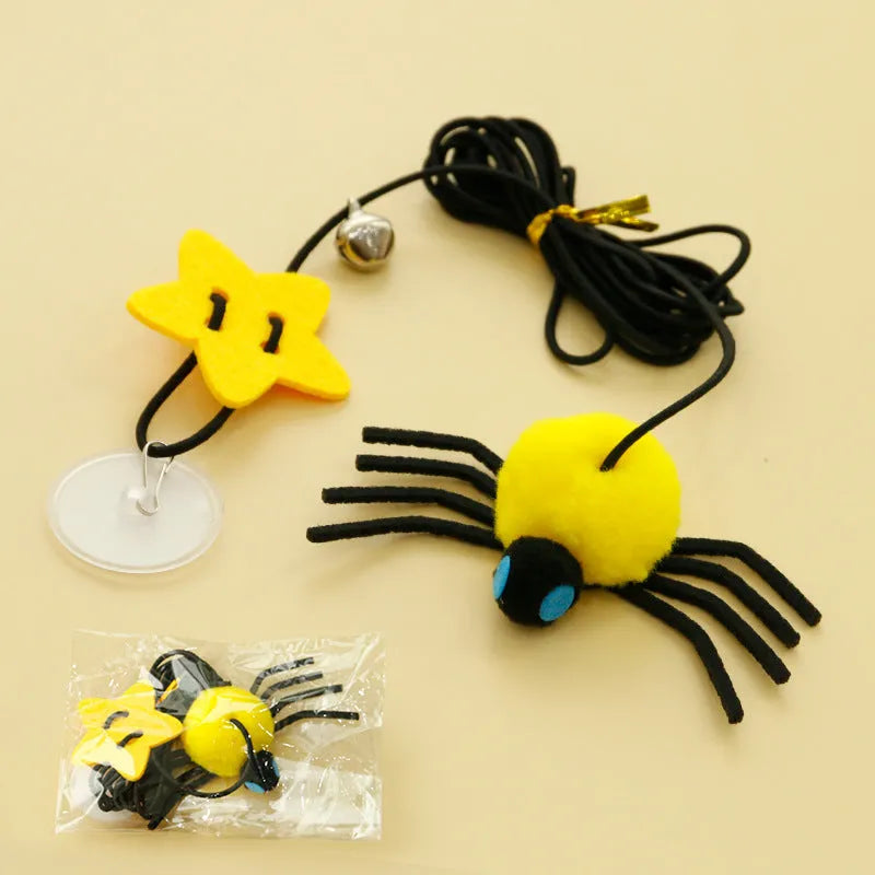 Red and yellow hanging cat toy with elastic rope, feathers, and a bell spider attached to a door.