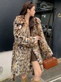 Women's grey faux fur mid-length winter coat with a fur collar and pockets on a model.