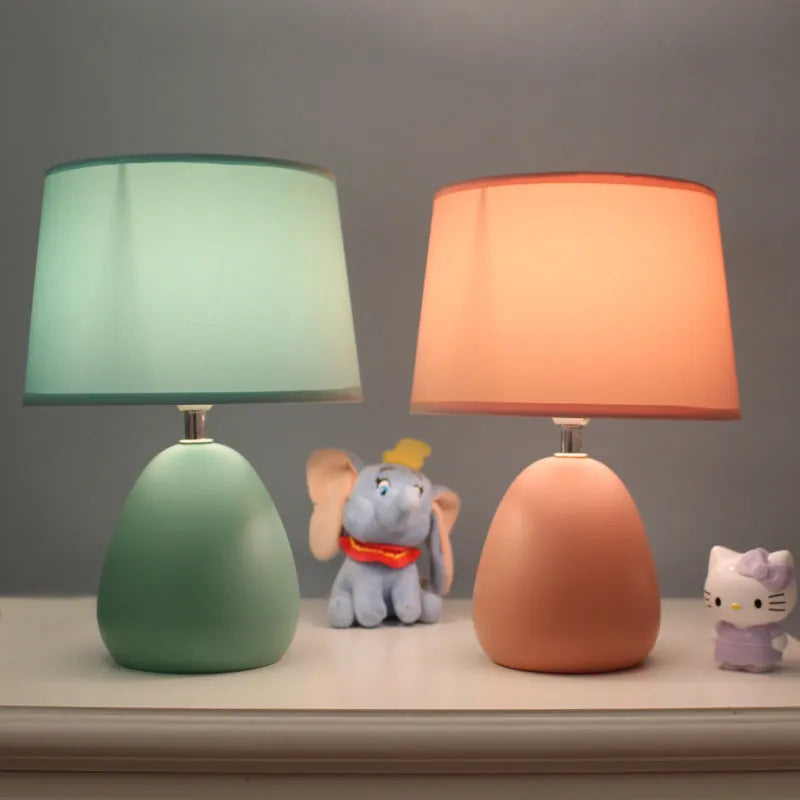 Small Nordic minimalist ceramic desk lamp in pink with LED light on desk