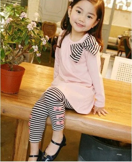 Pink cotton two-piece clothing set for a girl, shown on a hanger.