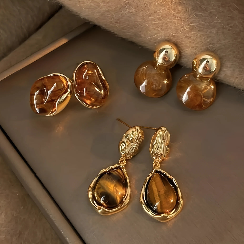 Three pairs of geometric women's earrings with tassel details in irregular, wafer, and water drop styles.