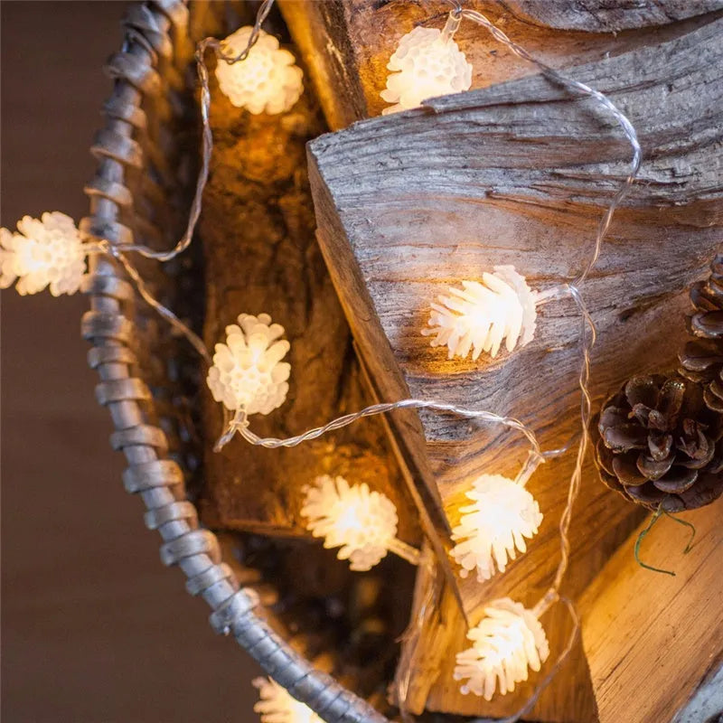 Battery-powered warm white LED pine cone fairy lights draped decoratively on a surface.