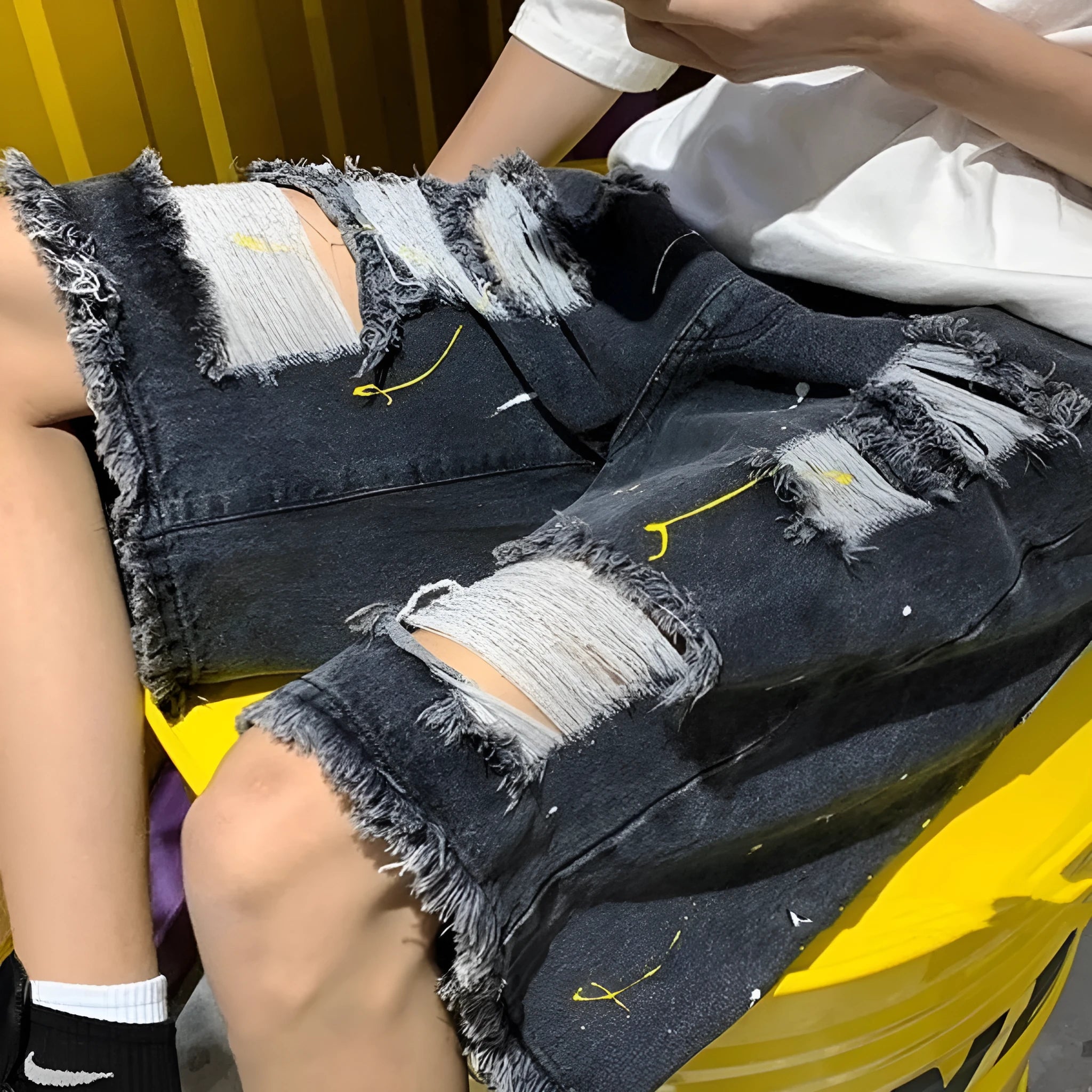Men's loose fit denim shorts with water-washed hole design in black cotton blend fabric