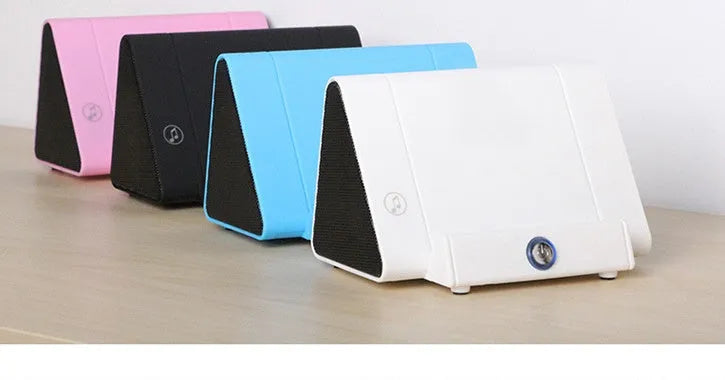 Mobile phone stand speaker in black with phone resting on stand showing speaker grille