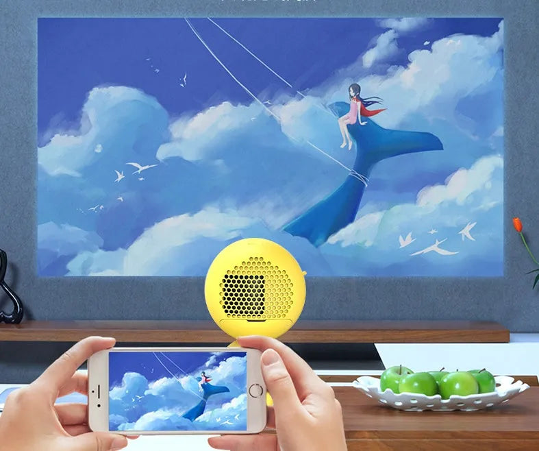 YG220 white or yellow LED projector displaying an image on a wall, showing front design and compact size.