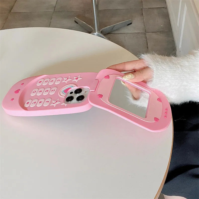 Light pink silicone flip phone shape case with mirror for iPhone, showing cute cartoon style.