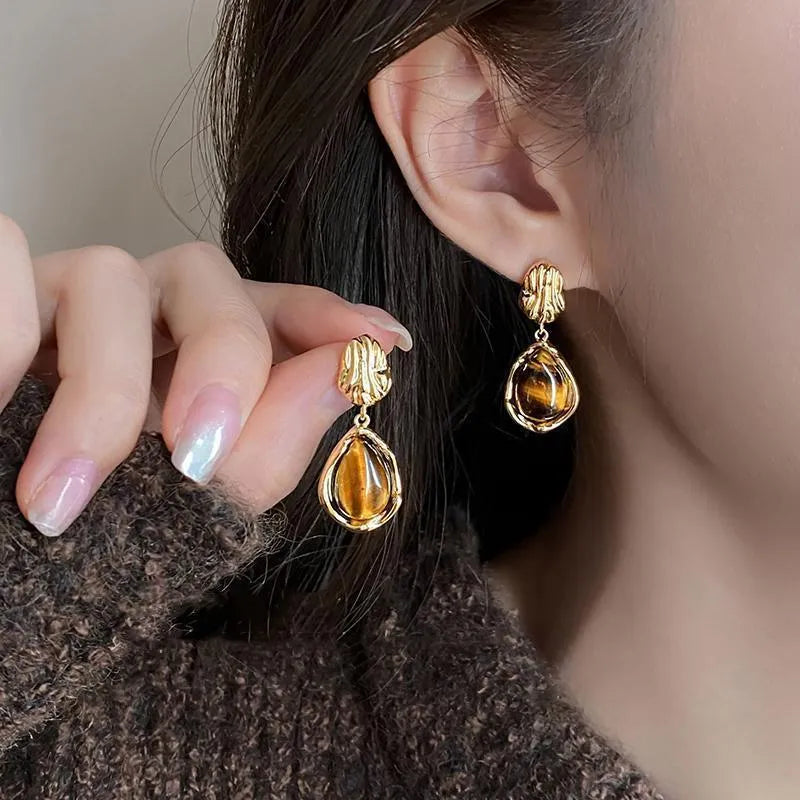 Three pairs of geometric women's earrings with tassel details in irregular, wafer, and water drop styles.