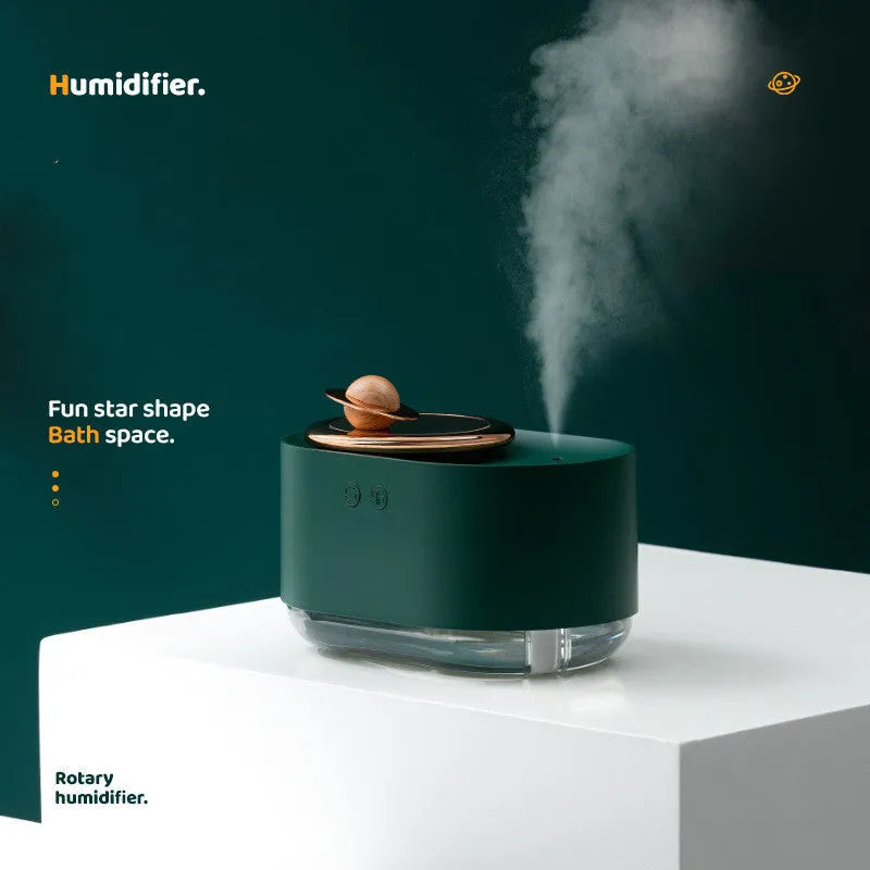 Green rotating planet-shaped humidifier with night light on a wooden table next to a USB cable.