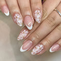 Short glossy almond false nails with French style and glitter powder flower design