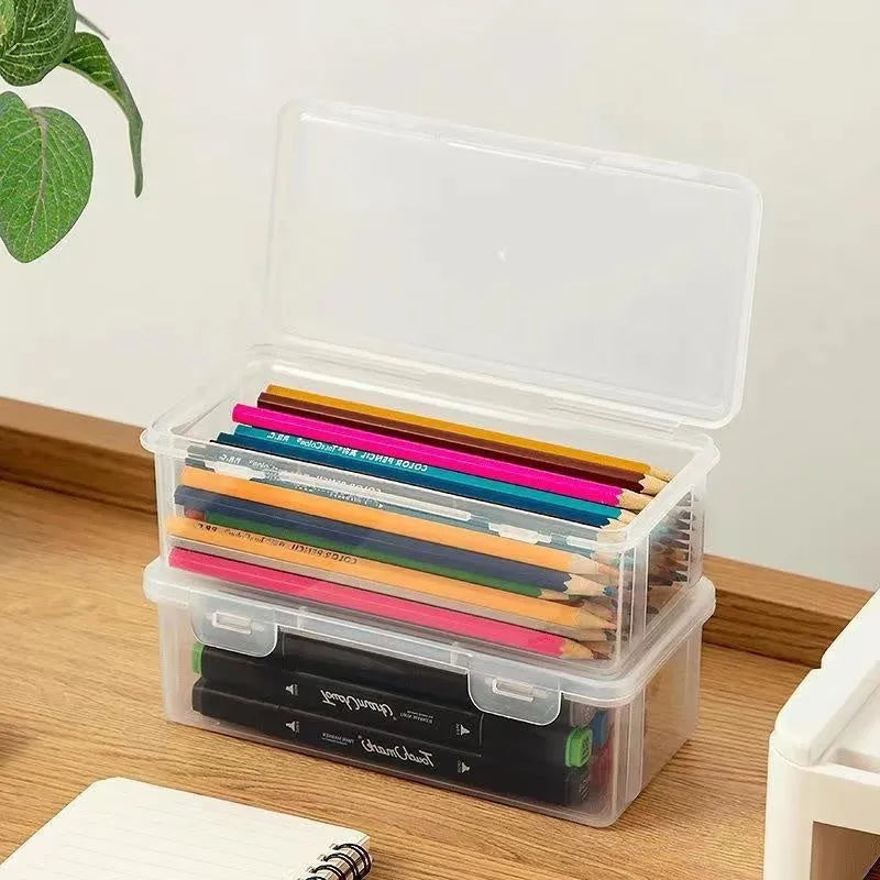 Transparent plastic stationery storage box containing pencils and drawing supplies