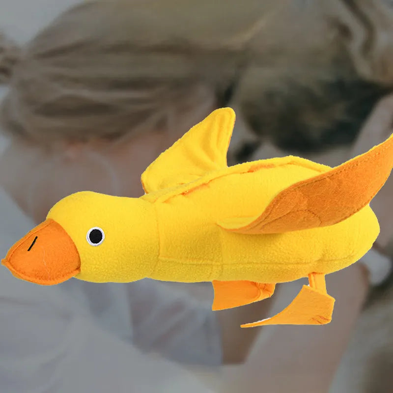 Yellow plush dog toy with attached rubber duck and a treat slot on a white background.