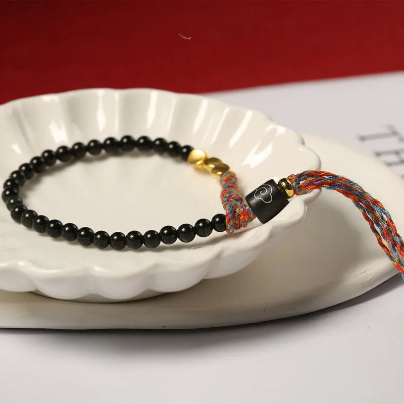 Hand-woven obsidian bead bracelet strap on a wrist, showing its 4mm width and dark colour.